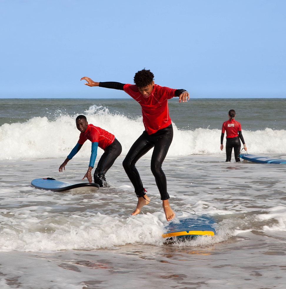 Trois jeunes qui font du surf